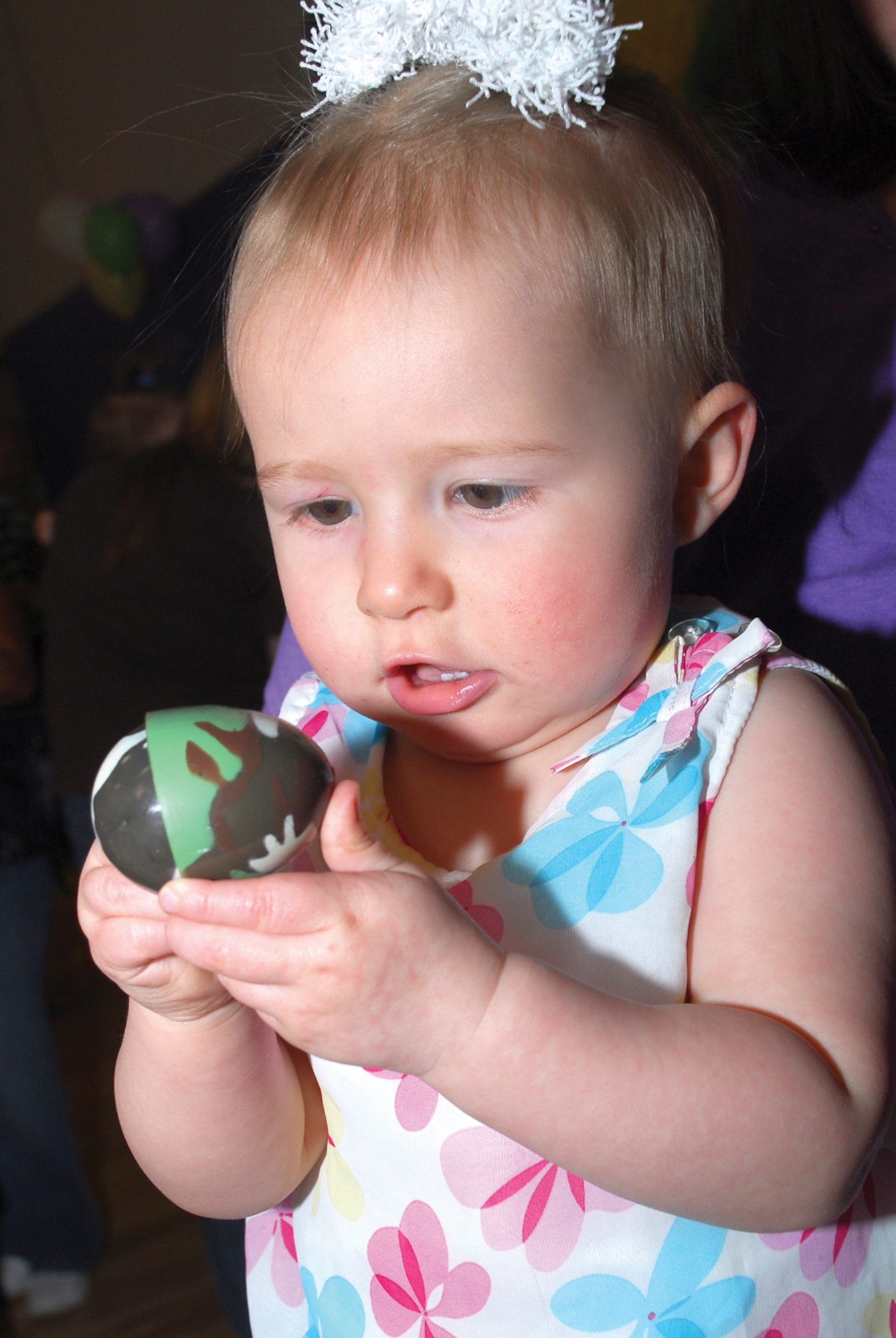 Aubrey Cappiello, 1, examines an Easter egg she picked up during the Luke Air Force Base “Eggstravaganza” held at the youth center, April 3. (U.S. Air Force photo/ Airman 1st Class Tracie Forte
