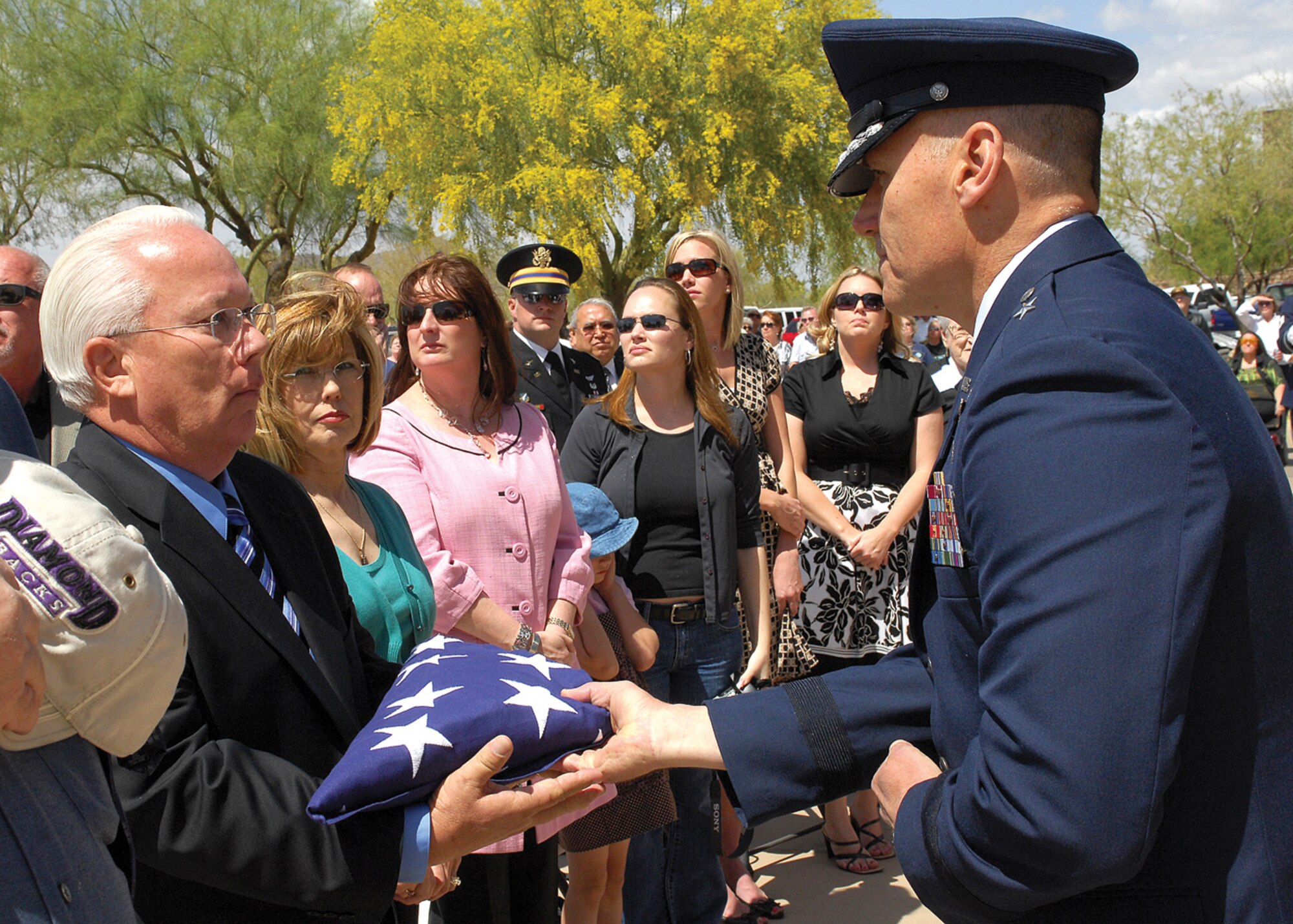 Brig. Gen. Kurt Neubauer, 56th Fighter Wing commander, presents the American flag to Mike Hopper at the funeral ceremony for his brother, Lt. Col Earl Hopper April 3 at the National Memorial Cemetery of Arizona in Phoenix. Colonel Hopper died in 1968 after being shot down in his F-4 Phantom while patrolling the North Vietnamese-Laotian border during the Vietnam War. His remains were recovered from a mountain in Laos and returned to his family.  (U.S. Air Force photo/Photos by Tech. Sgt. Raheem Moore)