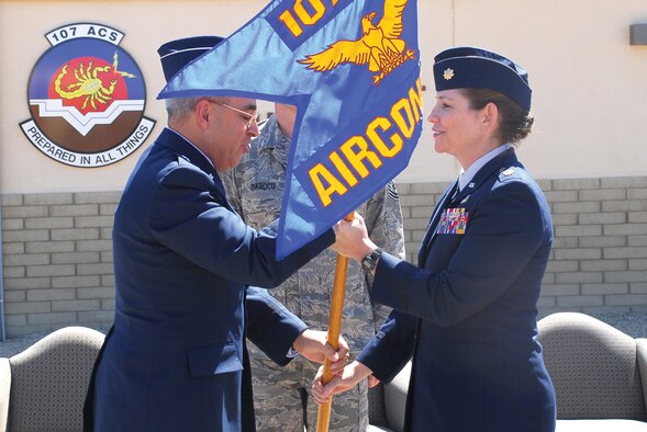 Brig. Gen. Michael Colangelo, Arizona National Guard commander, hands Maj. Lynda Lovell the squadron’s flag as she assumes command of the 107th Air Control Squadron at Bldg. 1382, Sunday. Lt. Col. Pamela Jackson relinquished command during the change-of-command ceremony. The 107th ACS, an Air National Guard unit, moved to Luke in February from their old location at Papago Park in Phoenix. (U.S. Air Force photo/Airman 1st Class Tracie Forte)