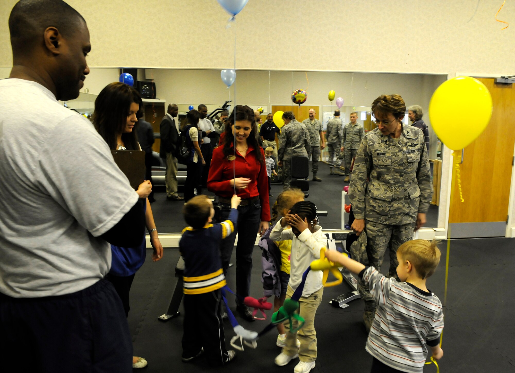 Col. Eden Murrie, 100th Air Refueling Wing commander, joins members of the 100th Force Support Squadron as well as military dependent children from the child development center, to open a new parent's exercise room in the RAF Mildenhall gym April 10.  The new space provides an area for children to play or watch movies, while parents can exercise nearby.  (U.S. Air Force Photo by Senior Airman Christopher L. Ingersoll)