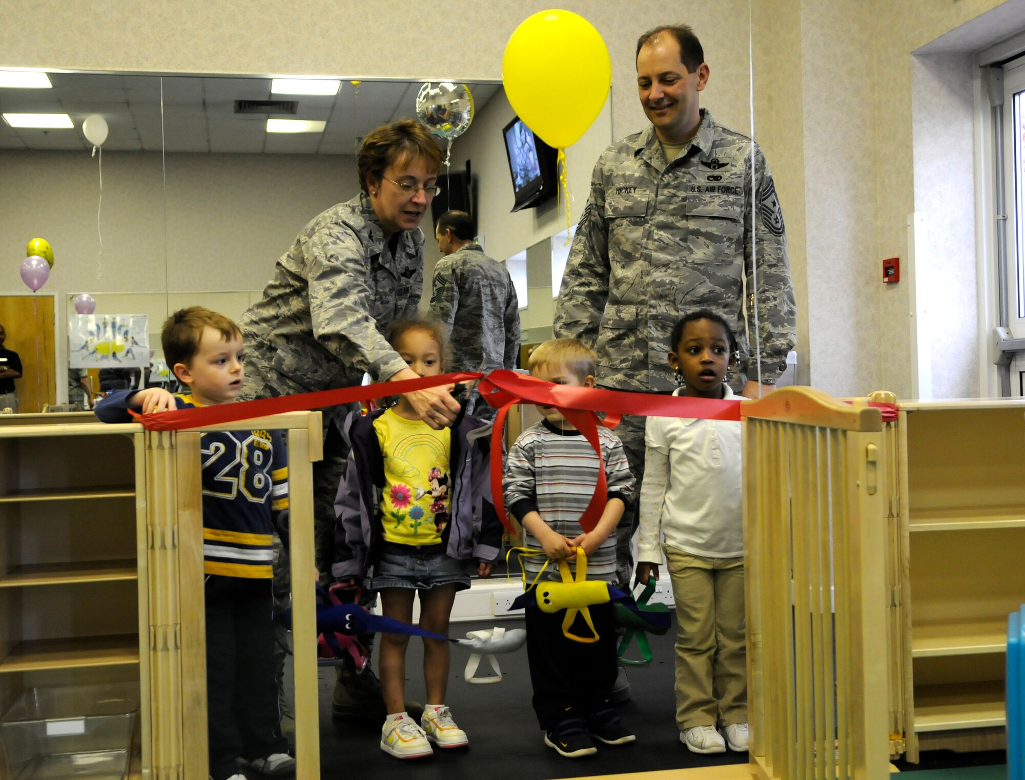 Col. Eden Murrie, 100th Air Refueling Wing commander, and Chief Master Sgt. Antonio Hickey, 100th Air Refueling Wing command chief, cut the ribbon to open the new parent's section of the North Side gym on RAF Mildenhall, April 10.  The new portion of the gym features small weights and cardio equipment for parents to exercise on while their children play in a penned-in area nearby.  (U.S. Air Force photo by Senior Airman Christopher L. Ingersoll)