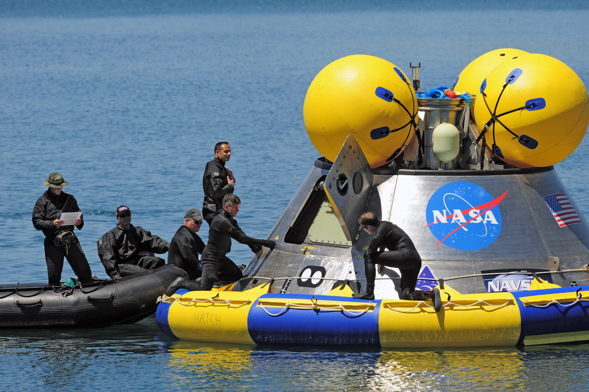 Pararescuemen test the hatch mechanism during recovery testing on a mockup of the Orion crew exploration vehicle March 8 at the Trident Basin at Port Canaveral, Fla. The team also tested an inflatable flotation collar (the blue and yellow ring seen around the base of the capsule), which is designed both to stabilize the capsule after water landing and provide a platform for recovery personnel to stand on during the operation. Reservists from the Air Force Reserve's 920th Rescue Wingprovide contingency medical and recovery support for all NASA shuttle launches. (U.S. Air Force photo/Tech. Sgt. Paul Flipse) 