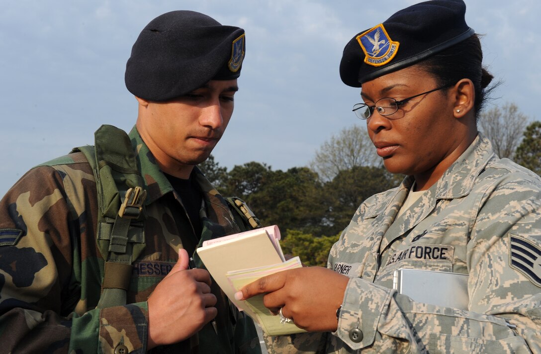 LANGLEY AIR FORCE BASE, Va. -- Staff Sgt. Ursula Warner, 1st Security Forces Squadron trainer, shows Airman 1st Class Joel Hesser, 1st SFS installation entry controller, the basics of writing a ticket April10. This was part of an operation to enforce the 25 mph speed limit on Nealy Avenue near the dental clinic and the hospital.  (U.S. Air Force photo/Airman 1st Class Zachary Wolf)   