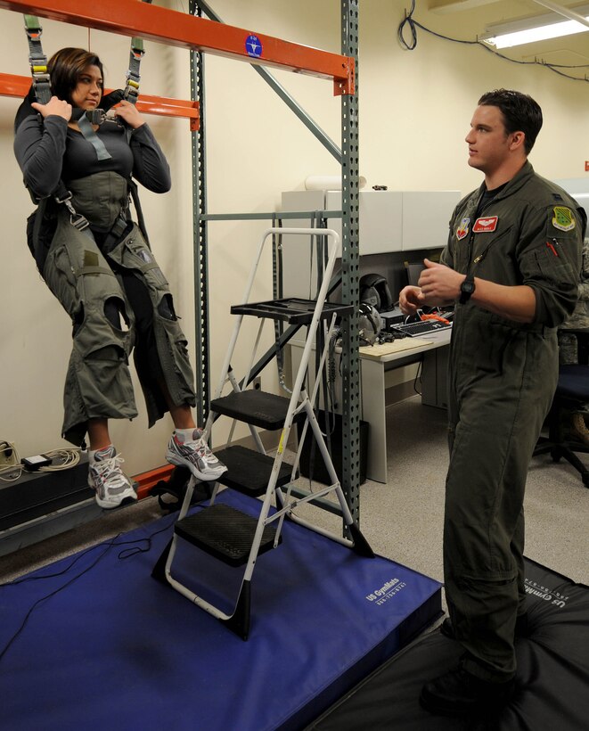 LANGLEY AIR FORCE BASE, Va.-- Bianca Martinez, WTKR Channel 3 broadcaster, undergoes hanging harness training with Capt. Alex Riegle, 71st Fighter Squadron pilot April 9. Mrs. Martinez was preparing for her flight in an F-15 Eagle as part of a series entitled "Do My Military Job." (U.S Air Force photo/Airman Rebecca Montez)