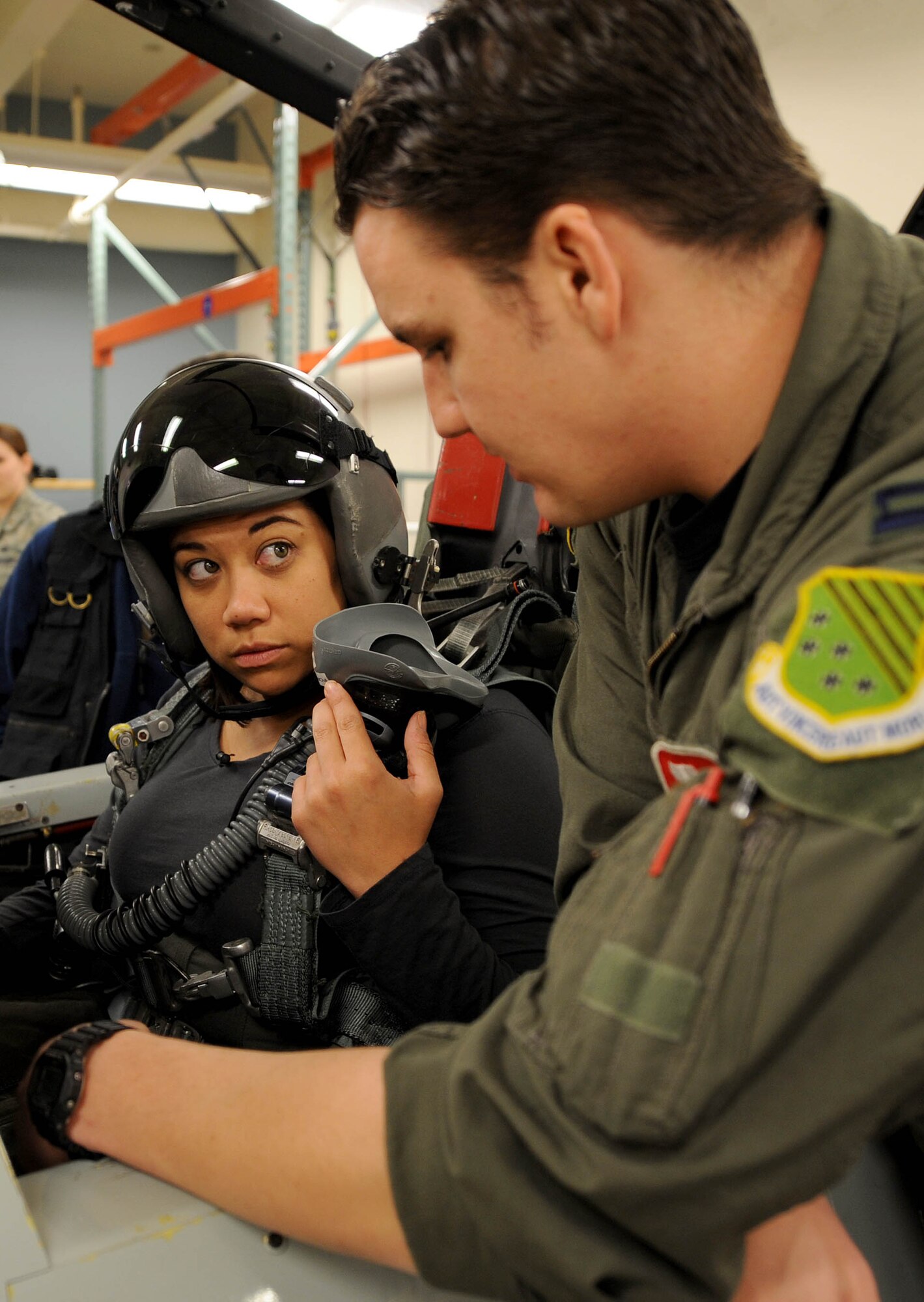 LANGLEY AIR FORCE BASE, Va.-- Capt. Alex Riegle, 71st Fighter Squadron pilot, explains to Bianca Martinez, WTKR Channel 3 broadcaster, about different control functions in a training cockpit April 9. Mrs. Martinez was preparing for her flight in an F-15 Eagle as part of a series entitled "Do My Military Job." (U.S Air Force photo/Airman Rebecca Montez)