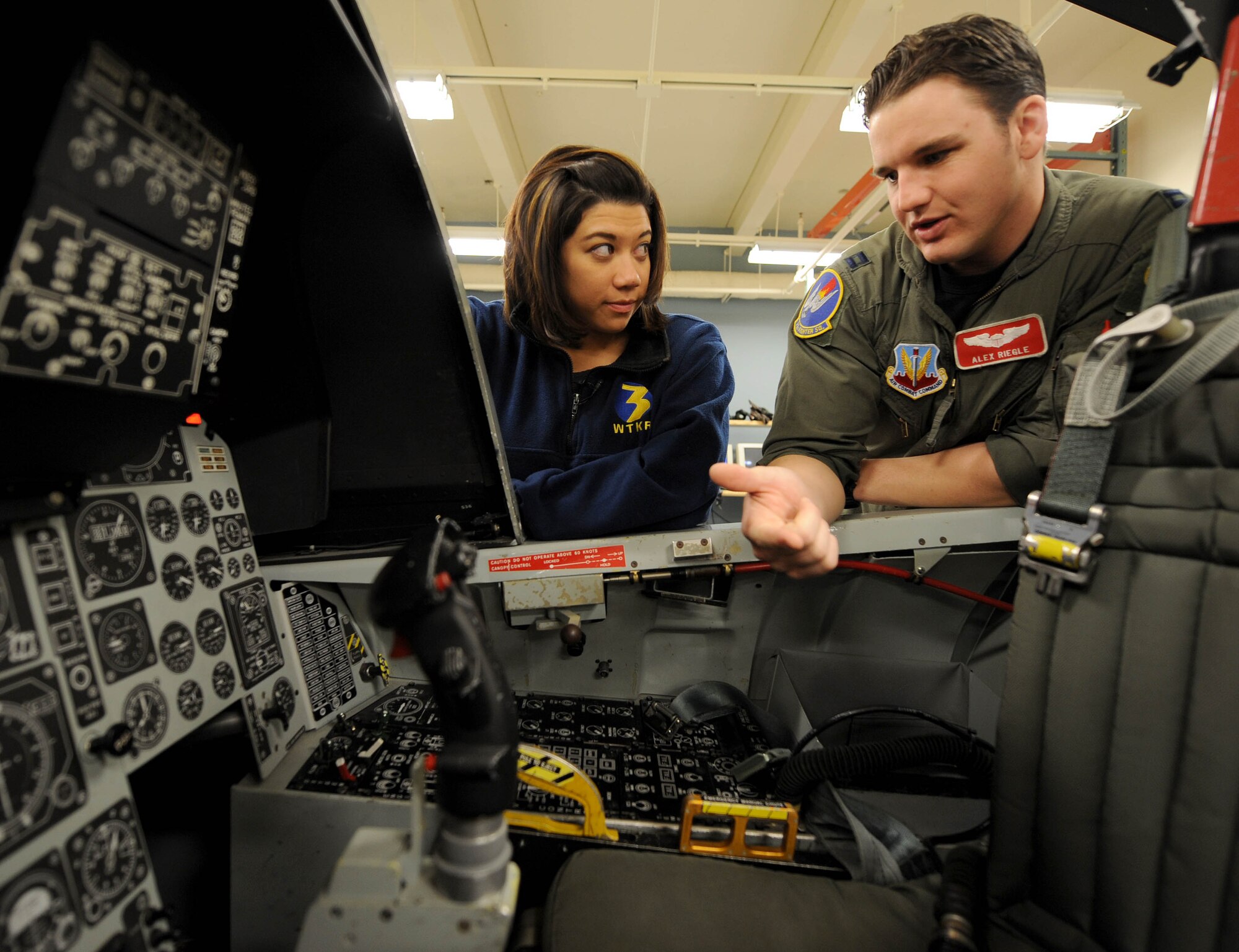 LANGLEY AIR FORCE BASE, Va.-- Bianca Martinez, WTKR Channel 3 broadcaster, is shown the inside of a training cockpit by Capt. Alex Riegle, 71st Fighter Squadron pilot, April 9. Mrs. Martinez was preparing for her flight in an F-15 Eagle as part of her series entitled "Do My Military Job." (U.S Air Force photo/Airman Rebecca Montez)