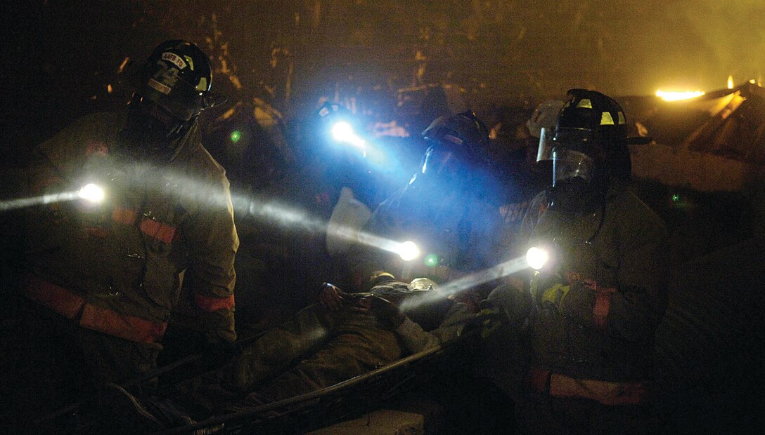 Airman 1st Class Shane Stonesifer, Mr. Michael McCartney, Senior Airman Scott Dulebohn and Airman 1st Class Shawn Suber, members of the Air Force District of Washington Chemical Biological Radiological Nuclear Explosive response force, transport a victim out of the "rubble room" during a training scenario at the Center for National Response in Gallagher, W. Va. April 2. The team is made up of personnel from the 316th Wing, the 79th Medical Wing and the 11th Wing and is a force that combines the bioenvironmental engineers, civil engineering readiness, emergency management and fire emergency services to respond to emergency situations in the National Capital Region. The Andrews team spent seven days training at the West Virginia National Response Center. (U.S. Air Force photo/ Senior Airman Renae Kleckner)