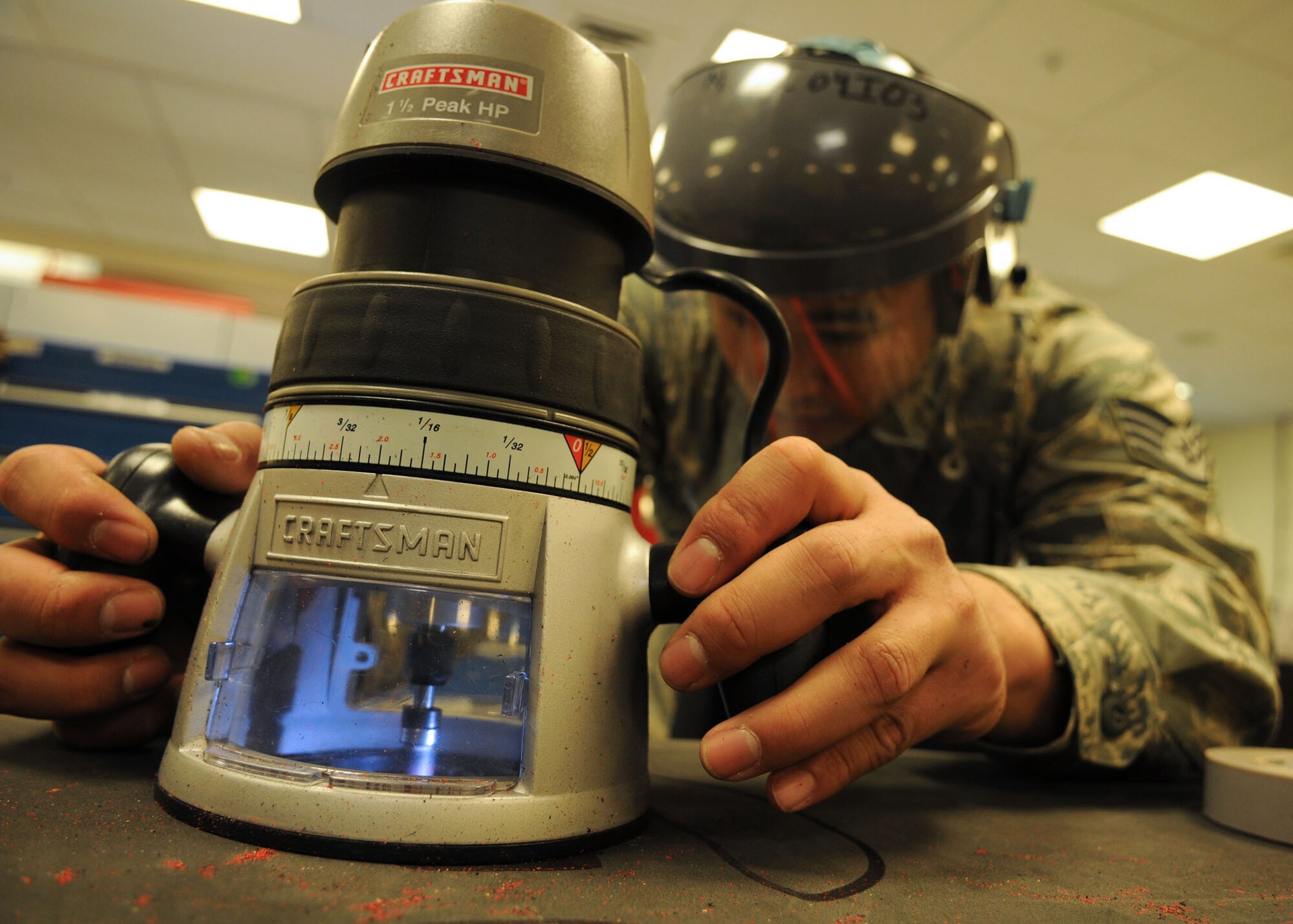Staff Sgt. Daniel Dela-Cruz, a crew chief from the 100th Maintenance Squadron, uses a router to cut into a foam board for tools as a part of the Air Force Smart Operation of the 21st Century program April 8 at RAF Mildenhall. With the cutouts, maintainers are able to reduce the time spent looking and accounting for tools and are able to use that time effectively towards mission accomplishment. (U.S. Air Force photo by Staff Sgt. Jerry Fleshman)