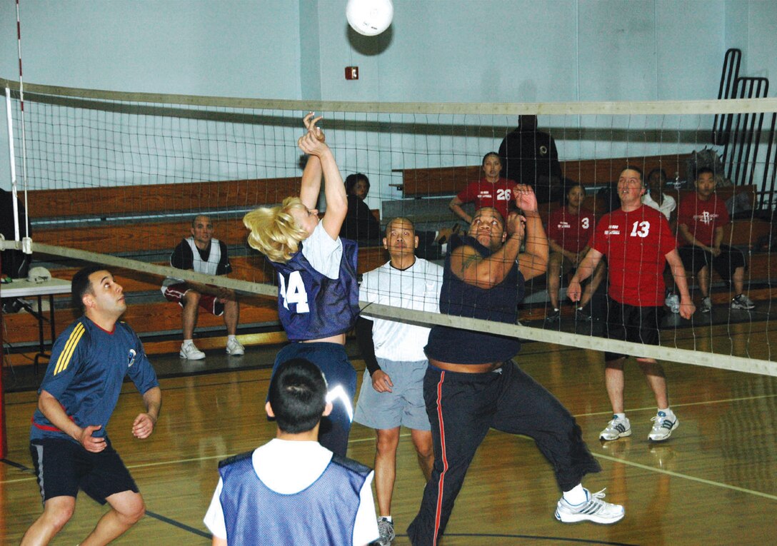 Cheryl Pinkerton, left, Logistics Readiness Squadron team member, returns a volley against the 779th Medical Group B defenders, during a doubleheader Volleyball game Tuesday at the East Fitness center. The games resulted in a tie, which made both teams’ season records  6-2. (U.S. Air Force photo/ Bobby Jones)
