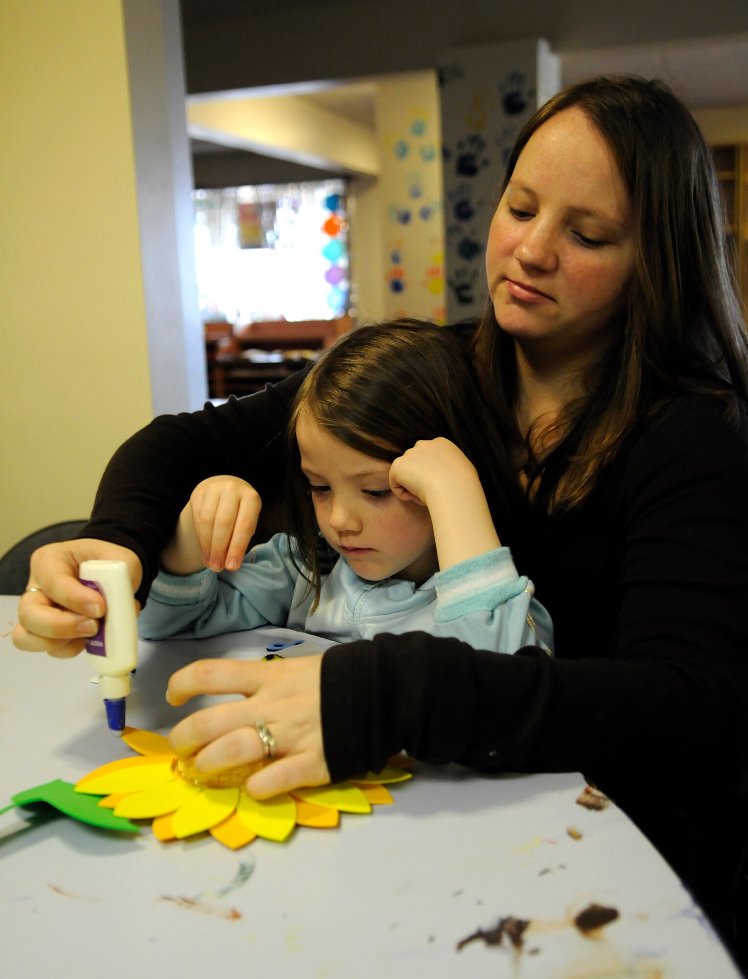 Emerald Basile and her mother Candice, family of Staff Sgt. Sean Basile of the 352nd Operations Support Squadron, make a sunflower hat during "Spring Break for Toddlers," an event held at RAF Mildenhall April 6.  The event is designed to give parents quality time with their children making crafts and having fun.  (U.S. Air Force photo by Senior Airman Christopher L. Ingersoll)