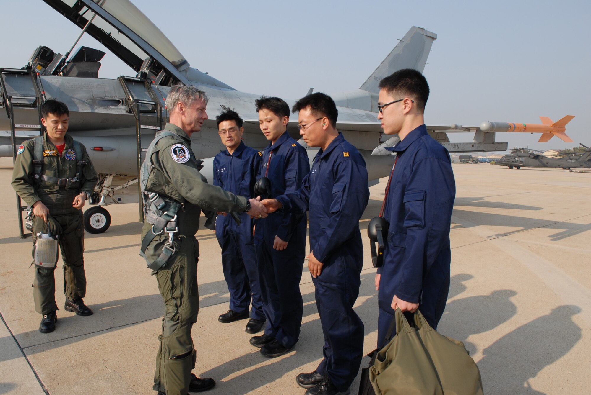 Army Gen. Walter Sharp, United States Forces Korea commander, thanks the Republic of Korea Air Force maintence airmen after his familiarization flight at Kunsan Air Base, ROK, April 10, 2009. General Sharp flew with the ROKAF's 38th Fighter Group in order to observe their combat capabilities and interoperability with U.S. forces. (USAF Photo By: Senior Airman Angela Ruiz)