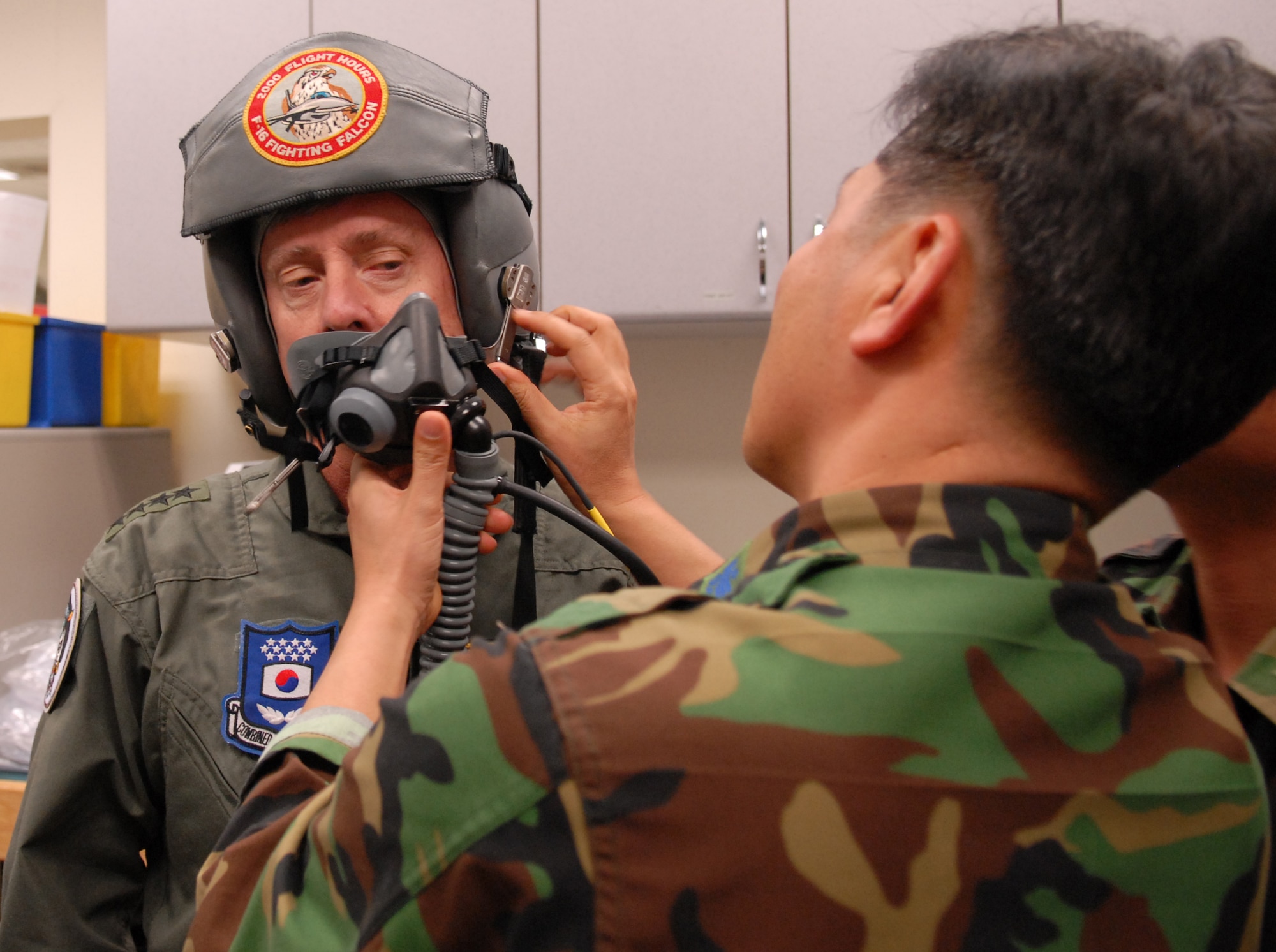 Army Gen. Walter Sharp, United States Forces Korea commander, is fitted for an oxygen mask by a Republic of Korea Air Force airman before departing for his familiarization flight at Kunsan Air Base, Republic of Korea, April 10, 2009. General Sharp flew with the Republic of Korea's Air Force's 38th Fighter in order to observe their combat capabilities and interoperability with U.S. forces.(USAF Photo By: Senior Airman Angela Ruiz)