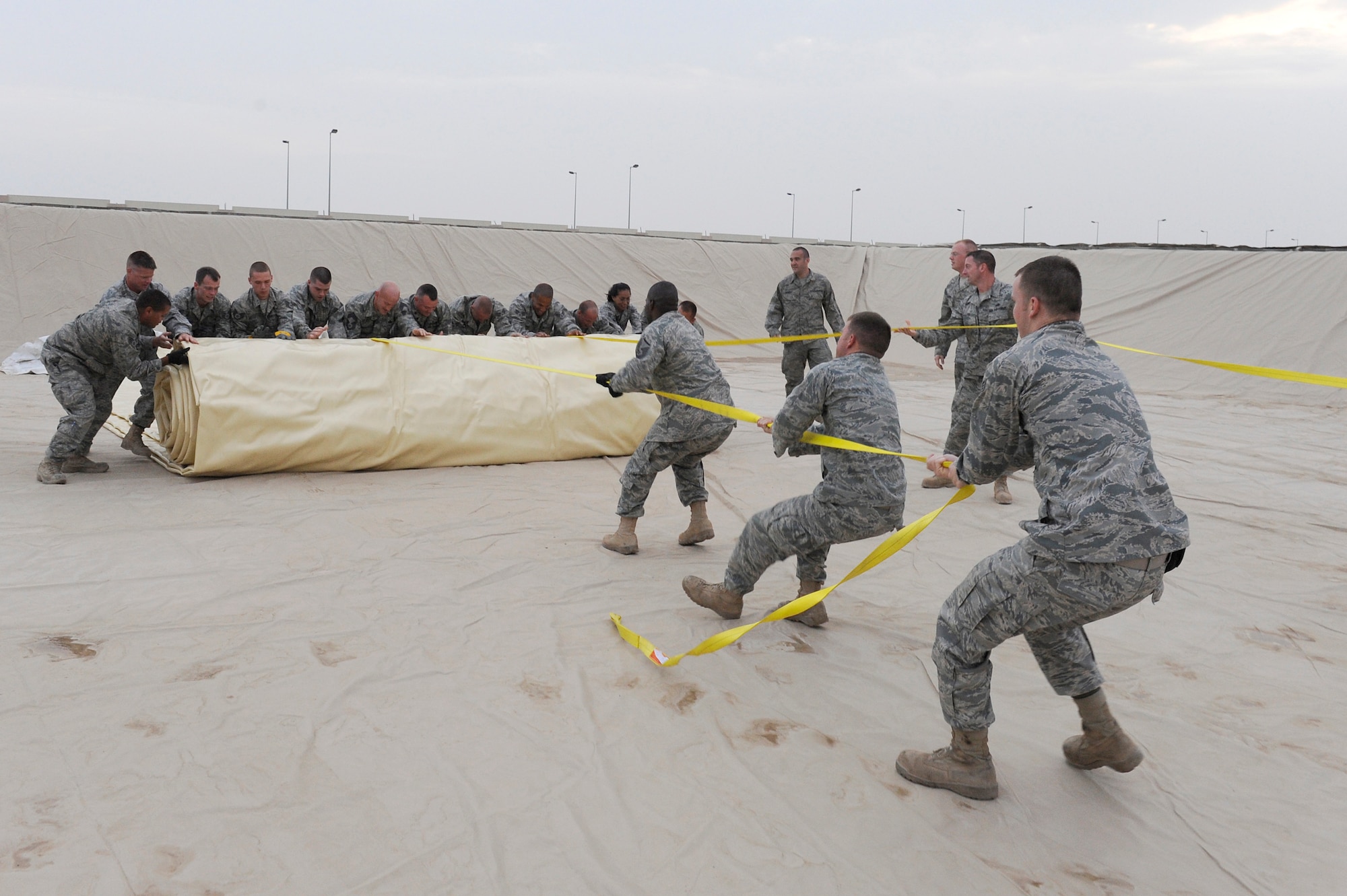 Members of the 380th Expeditionary Logistics Readiness Squadron, fuels flight roll out a fuel bladder, April 3 at an undisclosed location in Southwest Asia. The fuel bladder weighs about 6,000 pounds when empty. The new bladder will be filled with over 200,000 gallons of fuel. (U.S. Air Force photo by Senior Airman Brian J. Ellis) (Released)