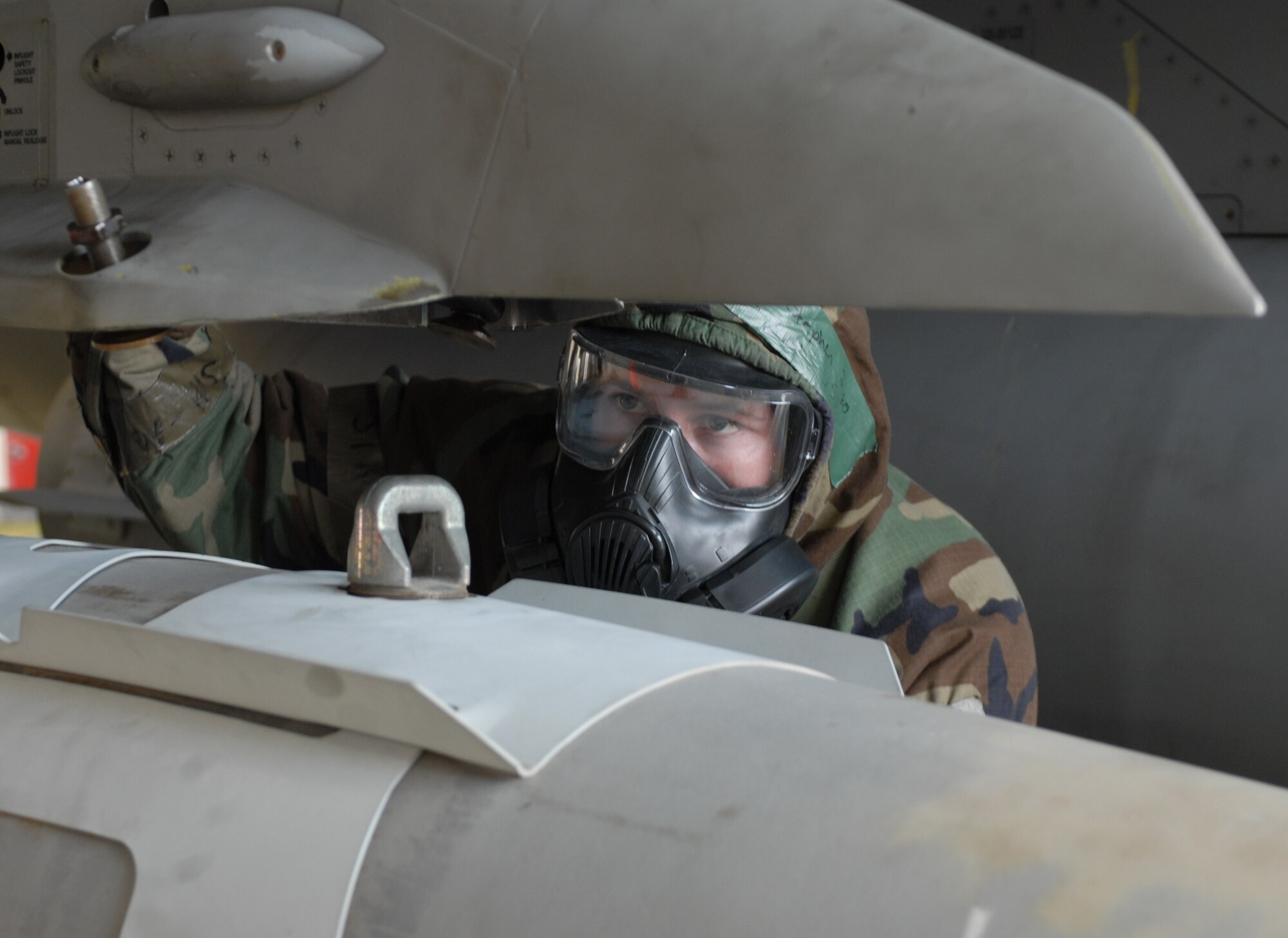 Staff Sgt. Stephen Dugas, 8th Aircraft Maintenance Squadron, helps load a bomb during a monthly Weapons Load Competition at Kunsan Air Base, Republic of Korea, April 10. Airmen participated in load competition while wearing chemical protection gear in preparation for the upcoming Operational Readiness Inspection. (U.S. Air Force Photo/Senior Airman Gustavo Gonzalez)