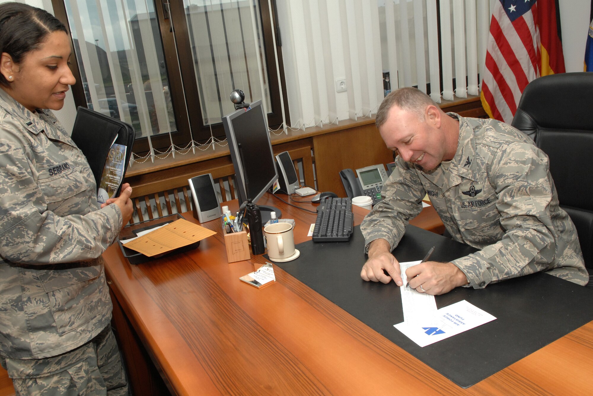 SPANGDAHLEM AIR BASE, Germany – Col Lee T. Wight, 52nd Fighter Wing commander, donates to the Air Force Assistance Fund as he is briefed on the campaign’s progress by 1st Lt. Cindy Serrano, the AFAF campaign officer.  The campaign runs until April 24. (U.S. Air Force photo by Master Sgt. Bill Gomez)