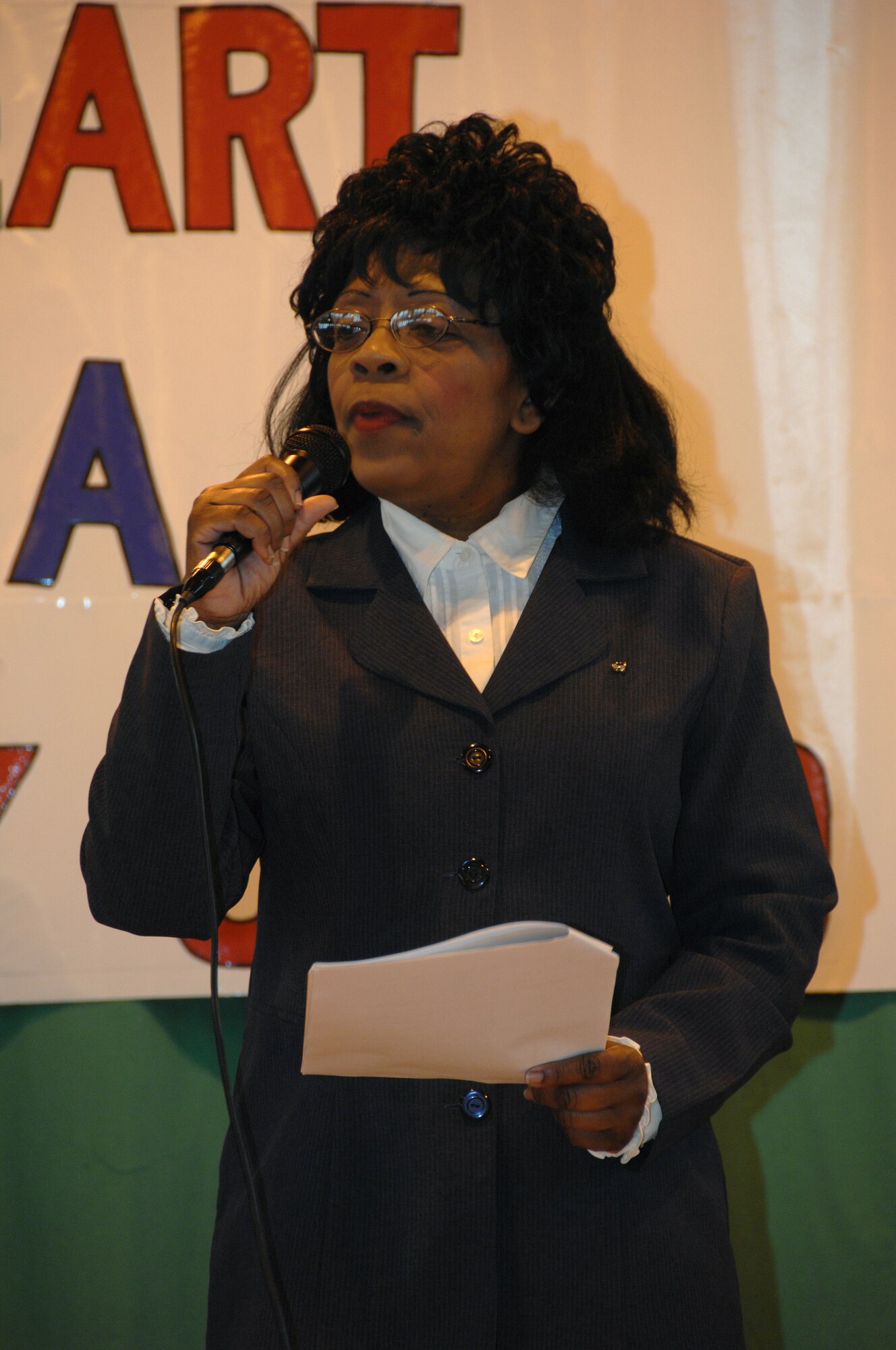 ROYAL AIR FORCE BASE LAKENHEATH--Mrs. De De Brown-Johnson, a first grade teacher with Lakenheath Elementary school, prepares the audience for what to expect during a performance in the gymnasium here April 2, 2009. The performance was an event during the month of the military child. Mrs. Brown-Johnson wrote and directed "The Heart of a Military Child" play the children recited.(U.S. Photo by Tech. Sgt. Christopher A. Campbell)