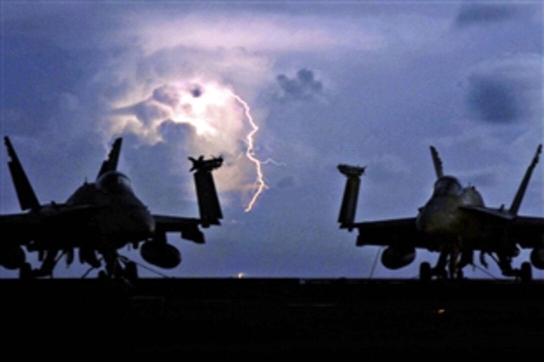 Lightning strikes behind two F/A-18C Hornet strike fighters on the flight deck aboard the aircraft carrier USS John C. Stennis in the Pacific Ocean, April 8, 2009. Stennis is on a scheduled six-month deployment to the western Pacific Ocean.