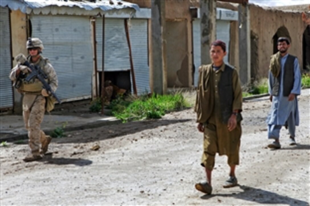 A U.S. Marine maintains security as he escorts displaced residents from the nearby village of Kwaja Jamal through the abandoned marketplace in Now Zad in Helmand province, Afghanistan, April 6, 2009. The Marine is assigned to Lima Company, 3rd Battalion,
8th Marine Regiment. Fearing insurgents, the former residents asked Marines to escort them through the marketplace to retrieve items left behind.
