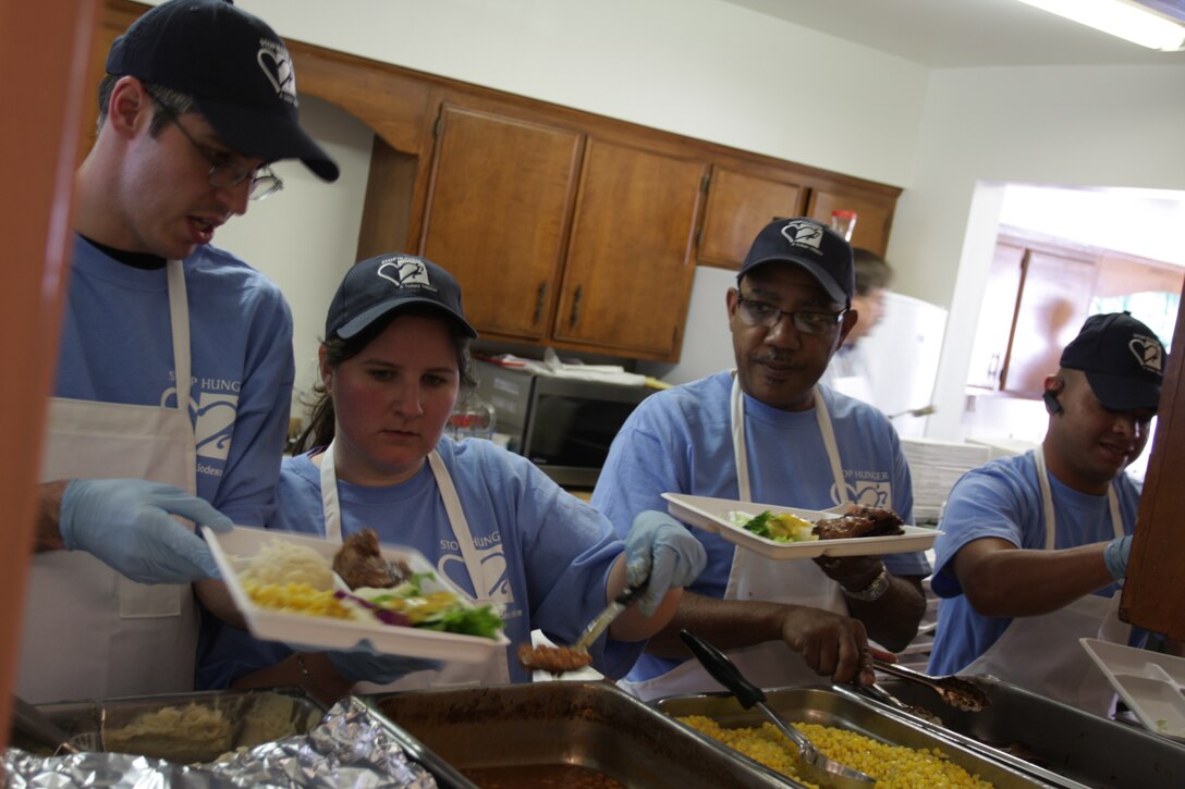 Sodexo employees from the Combat Center’s mess halls prepare meals for disadvantaged Twentynine Palms residents April 11 at the Little Church of the Desert.