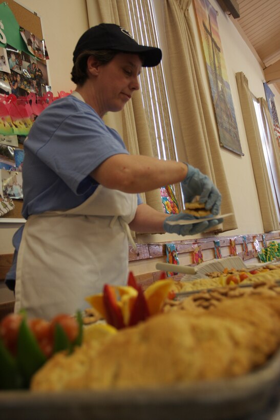 Lori Clemens, a Sodexo mess assistant at the Combat Center’s Lance Cpl. Chance R. Phelps Mess Hall, serves desserts to disadvantaged Twentynine Palms residents April 11 at the Little Church of the Desert.