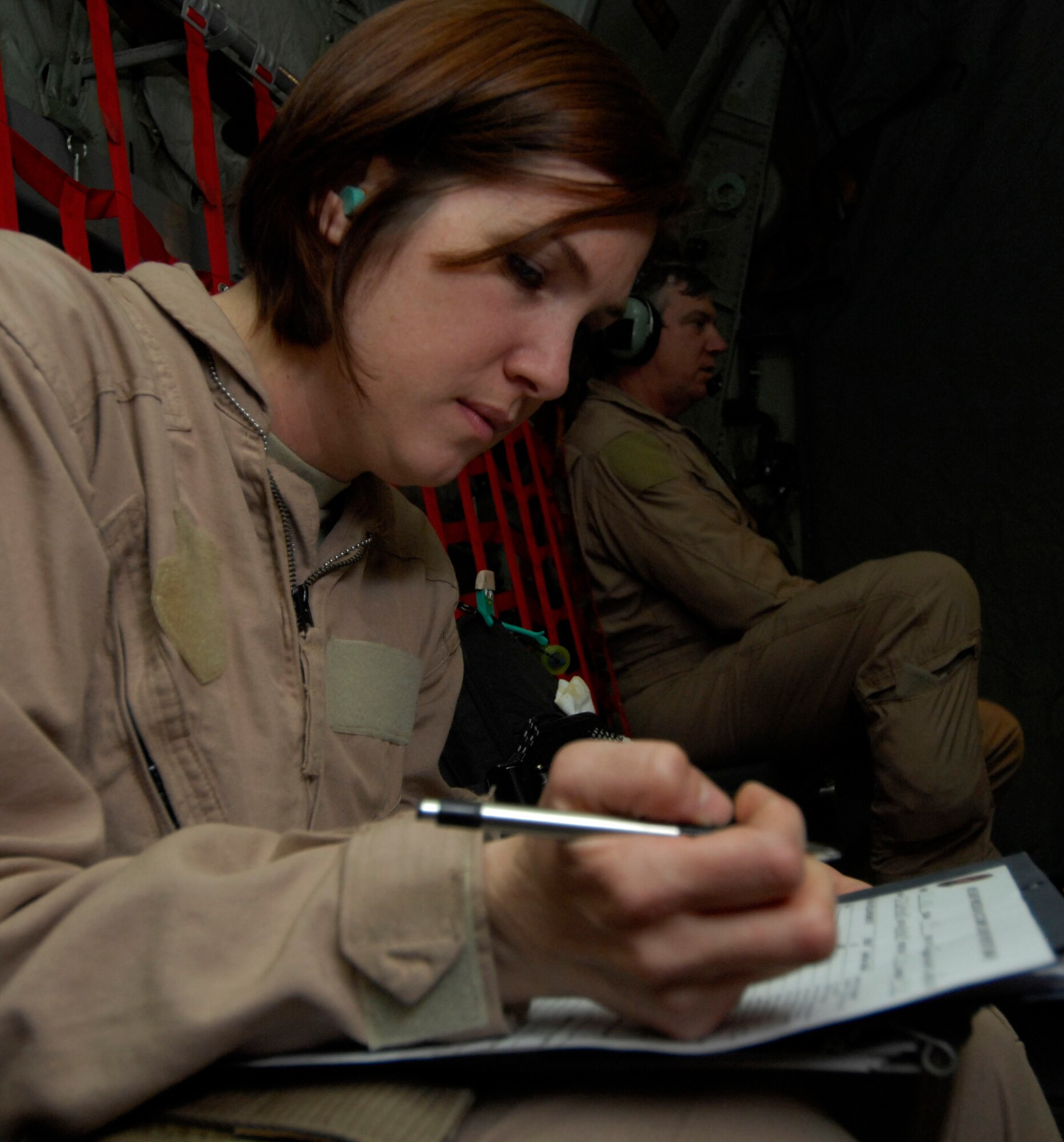 Capt. Susan McCormick, 455th Expeditionary Aeromedical Evacuation Flight, keeps track of the patient's paperwork in flight, going to Bagram Air Field, Afghanistan, March 26. Captain McCormick is required to log and keep track of each patient while enroute to their destination. She is deployed from Westover Air Reserve Base, Mass. (U.S. Air Force photo/ Senior Airman Erik Cardenas)(Released)