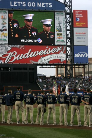 Marines march onto the field as part of the pre-game ceremony for the New York Mets inaugural game at Citi Field. The Marines unfurled an outfield-sized flag and flew F-18 Hornets overhead to kick-off the season in the new stadium. (Official U.S. Marine Corps Photo by Sgt. Randall A. Clinton)