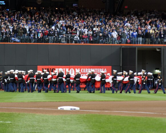 Marines from Marine Aircraft Group 49, 6th Communication Battalion, Recruiting Station New Jersey and 1st Marie Corps District march off Citi Field holding the American flag they unfurled during the opening ceremony. The Marines were chosen to present the flag and provide a fly-over during the pre-game ceremony at the new home of the New York Mets. (Official U.S. Marine Corps Photo by Sgt. Randall A. Clinton)