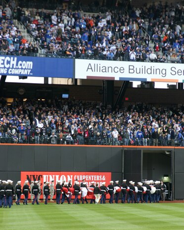 Marines from Marine Aircraft Group 49, 6th Communications Battalion, Recruiting Station New Jersey and 1st Marine Corps District march off the field after the pre-game ceremony for the New York Mets inaugural game at Citi Field. The Marines unfurled an outfield-sized flag and flew F-18 Hornets overhead to kick-off the season in the new stadium. (Official U.S. Marine Corps Photo by Sgt. Randall A. Clinton)