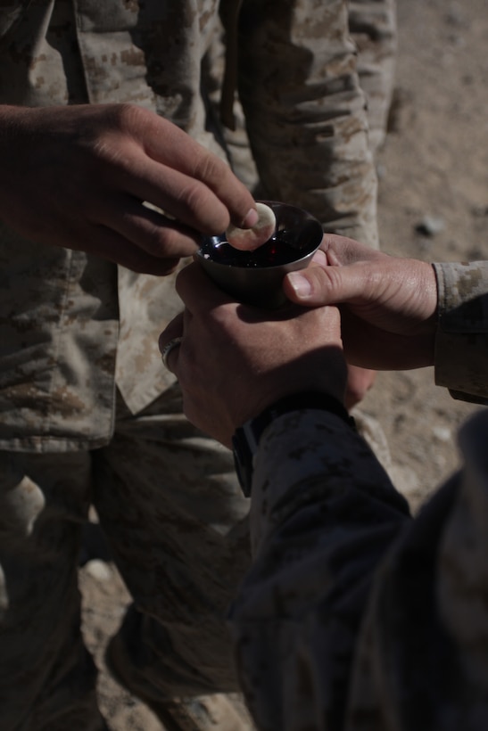 Marines and sailors from 2nd Battalion, 3rd Marine Regiment, take communion after an Easter sermon at a forward operating base in Combat Center’s Range 215 April 12.