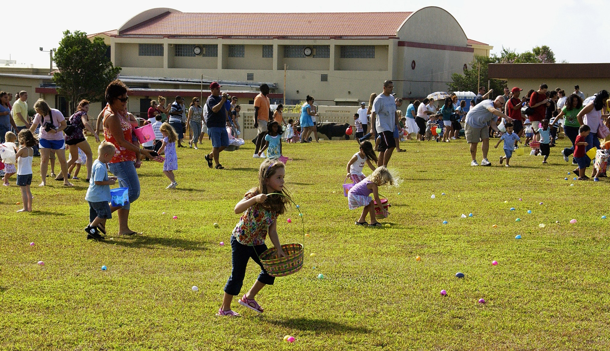 ANDERSEN AIR FORCE BASE, Guam -- Team Andersen children and their parents scurry after Easter eggs during the Easter egg hunt which was part of the Spring Carnival held on youth center grounds April 11. The children and parents gathered more than 3,000 eggs with prizes such as candy inside. (U.S. Air Force photo by Airman Carissa Wolff)                                