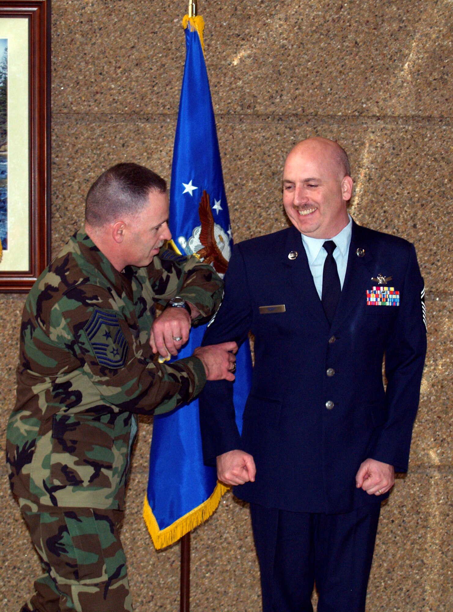 Senior Master Sgt. Todd M. Scott gets his new rank "pinned on" by 310 Space Wing command Chief Master Sgt. Rocky V. Hart during his promotion ceremony in Colorado Springs March 7 (U.S.Air Force photo/Capt. Maren P. Barney).
