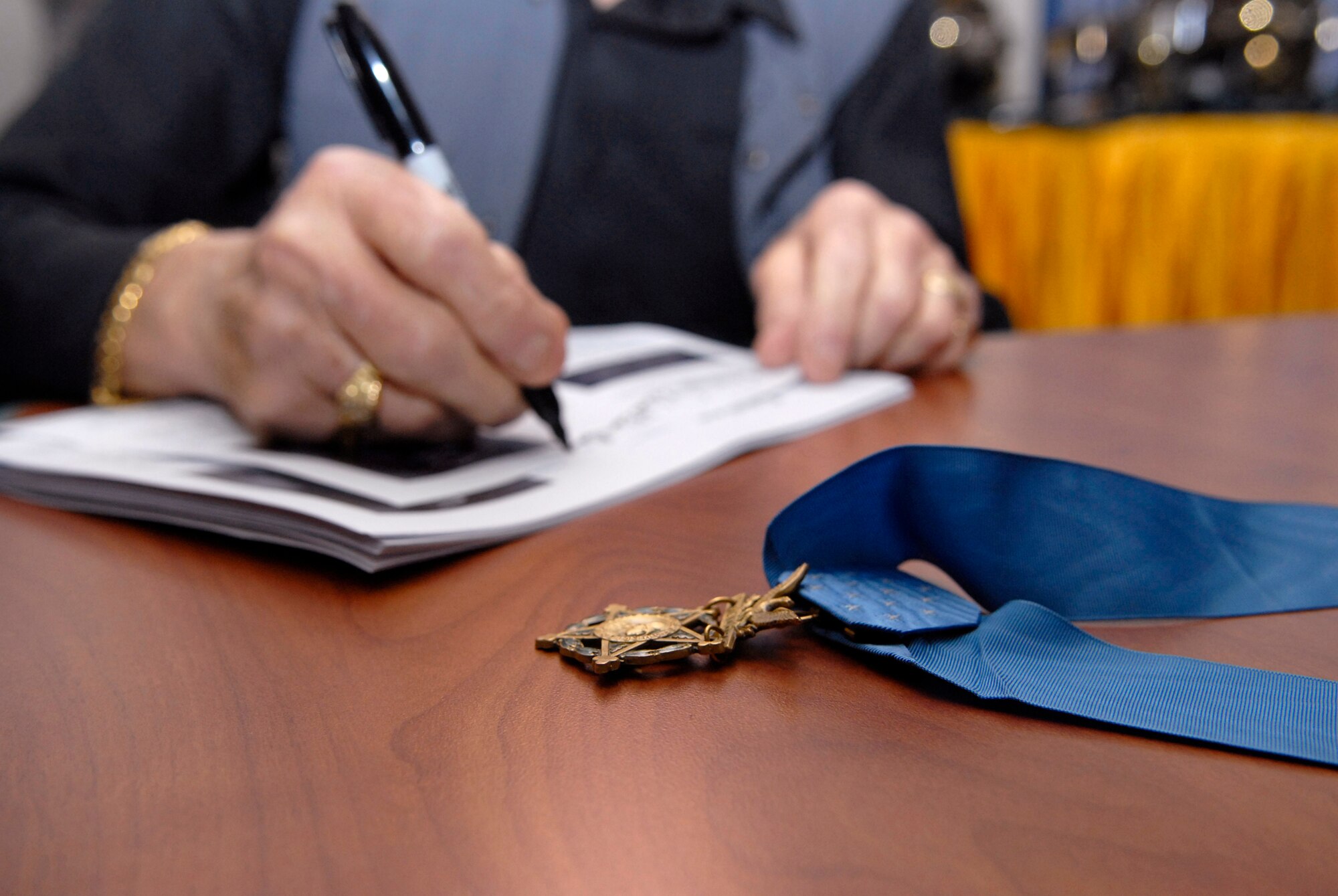 Retired Army Colonel Robert Howard signs copies of his Congressional Medal of Honor citation for servicemembers here during his visit, Apr. 8, 2009, at an undisclosed location in Southwest Asia.  Col. Howard and retired Army Command Sergeant Major Gary Littrell, were on base as part of a USO Medal of Honor tour of the U.S. Central Command's area of responsibility.  Both men are here to inspire and acknowledge servicemembers who are supporting Operations Iraqi and Enduring Freedom and Combined Joint Task Force - Horn of Africa.  (U.S. Air Force photo/Senior Airman Andrew Satran/released)