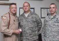 Lieutenant Gen. Gary North, 9th Air Force commander and commander, U.S. Air Forces Central, presents a coin to Tech. Sgt. Gary Mabe (center), deployed from Duke Field's 919th Maintenance Squadron in recognition of his recovery actions that quickly helped return two damaged aircraft to airworthiness in Operation Enduring Freedom.  Shown with them is Capt. Michael Schuyler, 1st Expeditionary Special Operations Maintenance Squadron commander.  (Courtesy photo)