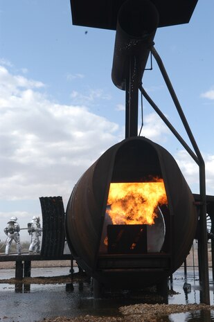 A firefighter crew, from Clark County Fire Department assigned to McCarran International Airport, prepare to enter an inferno inside of an aircraft mockup as part of a required Federal Aviation Administration training, held at Nellis Air Force Base, Nev., April 3. With the support of the Nellis fire department, the aircraft mockup or 'burn pit' was set ablaze in different sections to properly simulate the desired training atmosphere. (U.S. Air Force photo by Staff Sgt. Aileen Carter)

                                