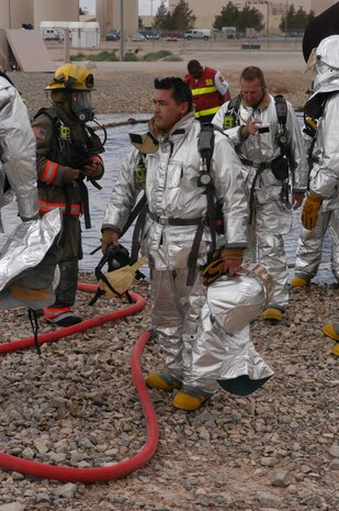 Jonathan Jones, a firefighter paramedic assigned to C-Platoon's Station 13 at McCarran International Airport's fire department, takes a quick break with his firefighter crew after completing the interior aircraft fire training portion of the required Federal Aviation Administration training at Nellis Air Force Base, Nev., April 3. The training also consisted of an external aircraft fire portion, where firemen hosed down external fires at the aircraft wheel breaks and engines. (U.S. Air Force photo by Staff Sgt. Aileen Carter)
               