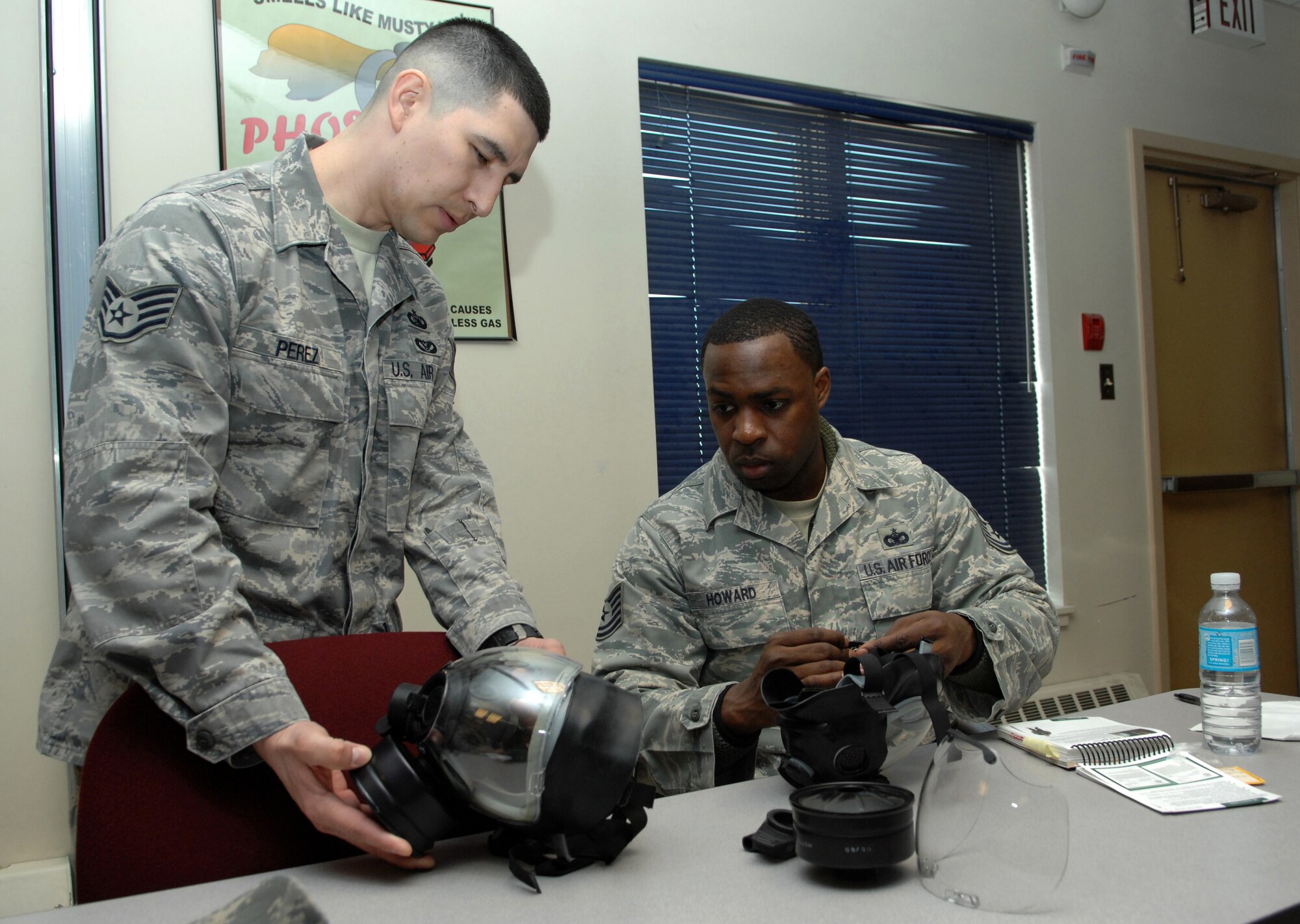 EIELSON AIR FORCE BASE, ALASKA -- Staff Sgt. Oscar Perez shows Tech Sgt. Chris Howard how to apply the second skin on a gas mask during a chemical warfare training class Apr. 7. Chemical warfare training teaches Airmen how to survive and operate in deployed environment or at home station. (U.S. Air Force photo/Senior Airman Christopher Boitz)