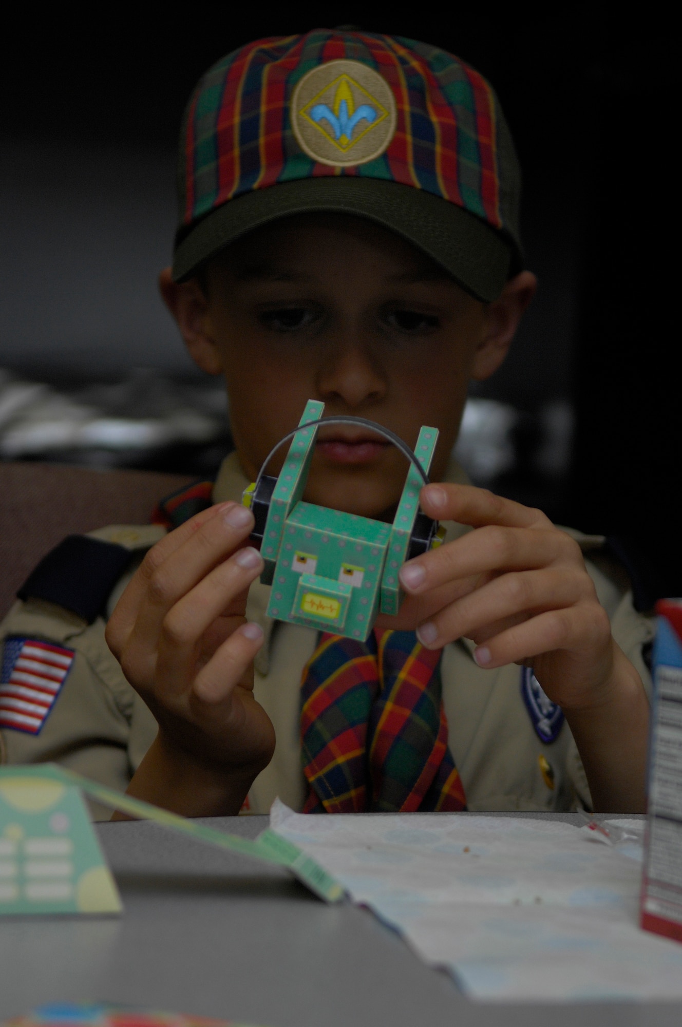 VANDENBERG AIR FORCE BASE, Calif. --  Deep in concentration, Chance Bohlander, a Vandenberg Cub Scout, examines a paper design of a robot April 9. Following one of the steps toward an art badge, the Scouts talked to Jan Kays, a 30th Space Wing Public Affairs graphic illustrator, at the graphics section of the PA office.(U.S. Air Force photo/Airman 1st Class Andrew Lee) 
 