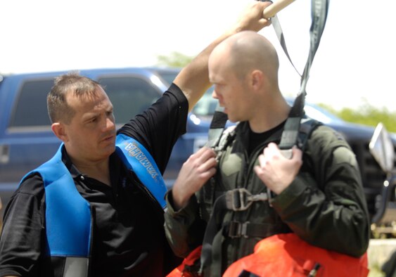 Tech. Sgt. Sherwood Brown (left), a U.S. Air Force survival, evasion, resistance, escape specialist, informs a crew member on what it will feel like when he's pulled through the water by a jet ski which will simulate a parachute being caught in the wind during refresher water survival training April 6 while in the waters adjacent to Hickam Air Force Base, Hawaii. (U.S. Air Force photo/Tech Sgt. Cohen A. Young) 
