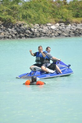 Tech. Sgt. Sherwood Brown (left), a 15th Operations Support Squadron survival, evasion, resistance, escape specialist, informs a crew member on what it will feel like when he's pulled through the water by a jet ski which will simulate a parachute being caught in the wind during refresher water survival training April 6 while in the waters adjacent to Hickam Air Force Base, Hawaii . (U.S. Air Force photo/Tech Sgt. Cohen A. Young) 