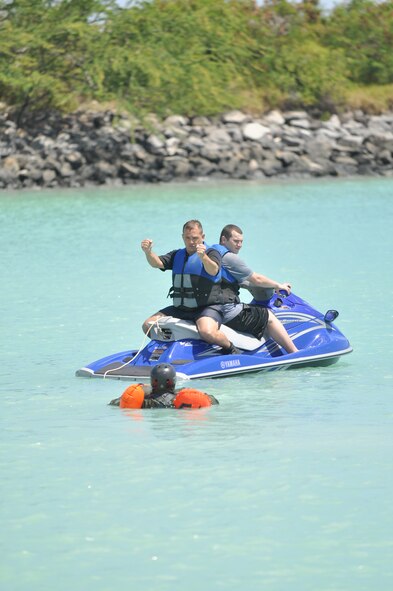 HICKAM AFB  -  U.S. Air Force Survival Evasion Resistance Escape Specialist Tech. Sgt. Sherwood Brown (left) of the 15th Operations Support Squadron, 15th Airlift Wing informs a crew member  on what it will feel like when he's  pulled through the water by a jet ski which will simulate a parachute being caught in the wind during refresher water survival training on April 6, 2009 while in the waters adjacent to Hickam AFB, Hawaii . (U.S.  Air Force photo/Tech Sgt. Cohen A. Young) 