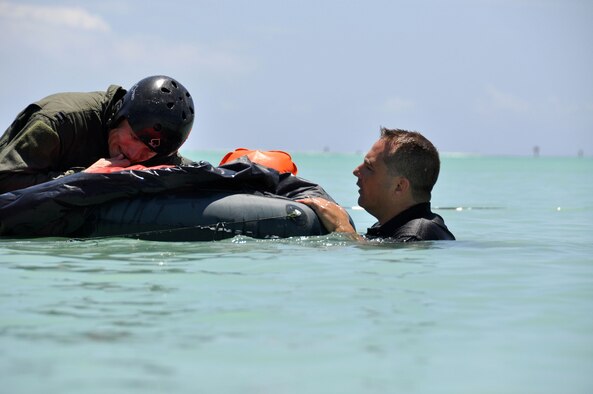 U.S. Air Force survival, evasion, resistance, escape specialist Tech. Sgt. Sherwood Brown of the 15th Operations Support Squadron at Hickam Air Force Base, Hawaii, monitors the progression of Capt. George Adams, 535th Airlift Squadron C-17 pilot, as he attempts to inflate various sections of his one-man life raft during refresher water survival training April 6 while in the waters adjacent to Hickami. (U.S. Air Force photo/Tech Sgt. Cohen A. Young) 
