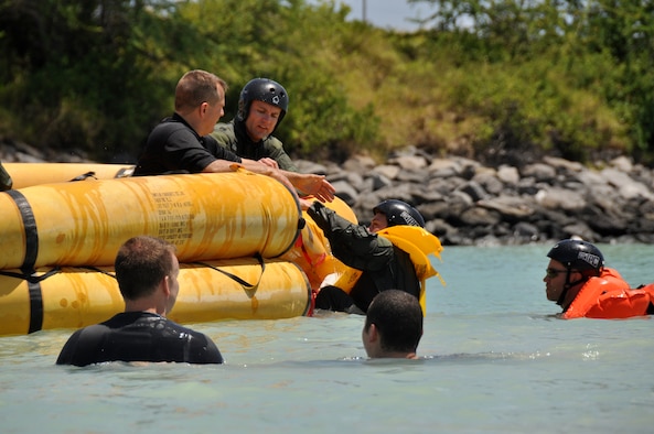 Tech. Sgt. Sherwood Brown, U.S. Air Force survival, evasion, resistance, escape specialist, instructs aircrew members on the proper way to pull other crew members out of the ocean and into a raft during refresher water survival training April 6 while in the waters adjacent to Hickam Air Force Base, Hawaii . (U.S. Air Force photo/Tech Sgt. Cohen A. Young) 