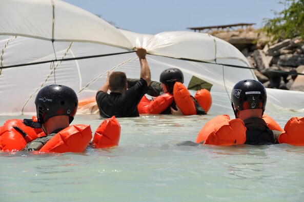 Tech. Sgt. Sherwood Brown, U.S. Air Force survival, evasion, resistance, escape specialist, briefs an aircrew member on the correct way to swim under a parachute canopy during refresher water survival training April 6 while in the waters adjacent to Hickam Air Force Base, Hawaii . (U.S. Air Force photo/Tech Sgt. Cohen A. Young)
