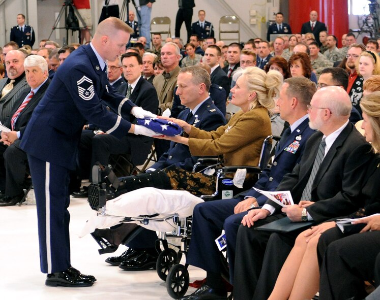 Senior Master Sgt. Rulon Walker, member of the 419th Fighter Wing Honor Guard, presents Cinde Mittuch with an American flag in memory of her husband, Col. Stephen E. Mittuch, 419th Maintenance Group commander. (U.S. Air Force photo/Staff Sgt. Kyle Brasier)