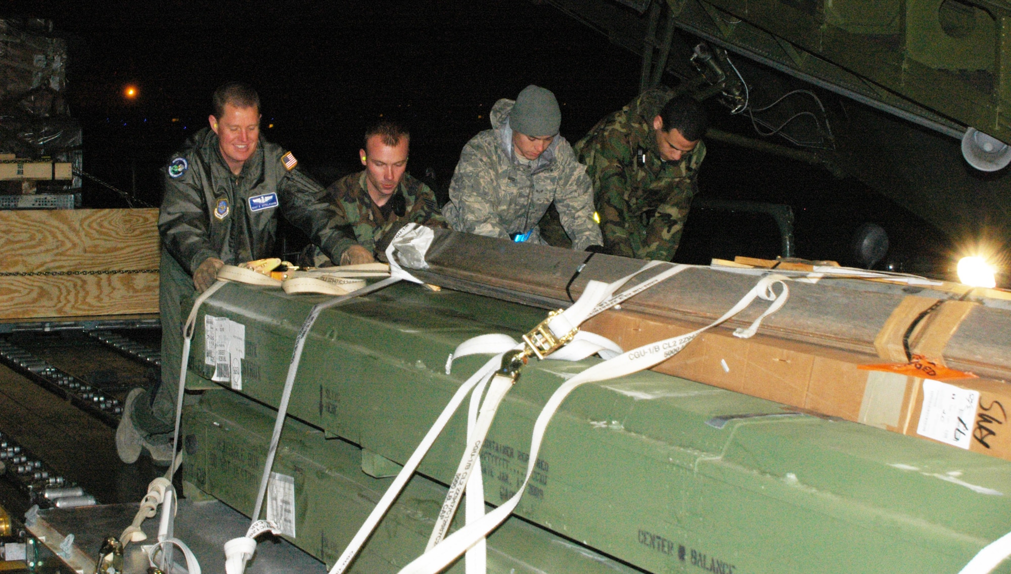 Master Sgt. Erik Appeldoorn (far left), 436th Airlift Wingloadmaster and C-5M crewmember, and Airmen from McGuire Air Force Base, N.J., load cargo onto the C-5M during it's first mission, March 28. The crew, consisting of 512th and 436th AW members and Lockheed Martin field service representatives, returned to Dover after a 13-day familiarization and aircraft training mission at Ramstein Air Base, Germany. The Spirit of Global Reach is the first of two C-5Ms at Dover AFB. (U.S. Air Force photo/Senior Airman Andria J. Allmond)