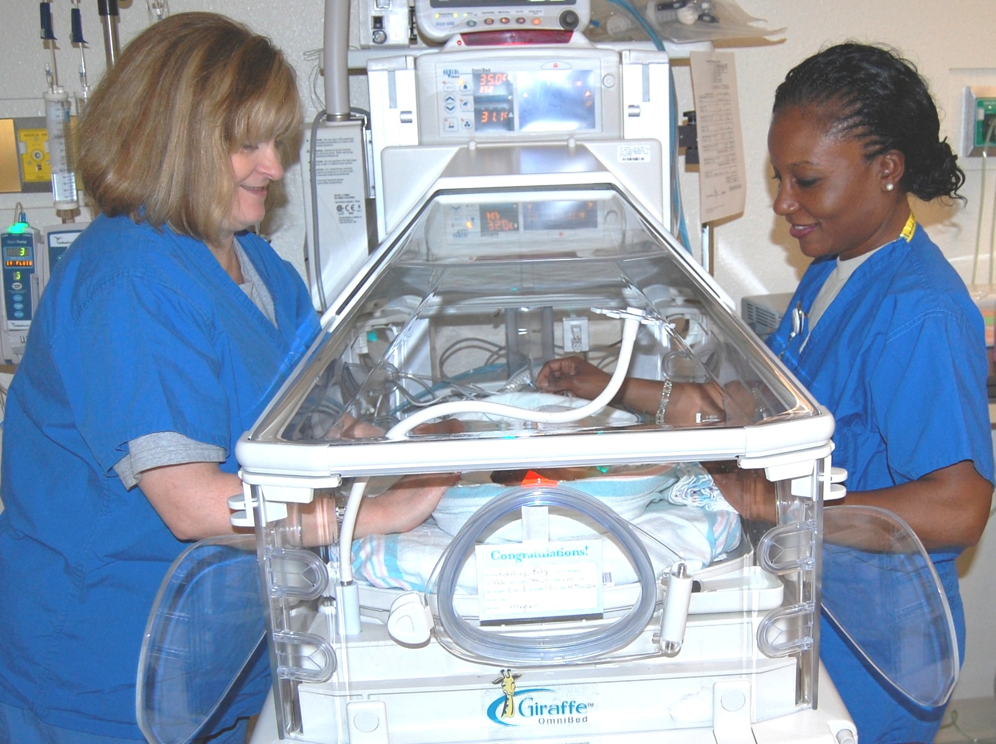 Neonatal intensive care nurses Susan Givens, left and Capt. Mickaelle Germain examine 3-day-old Riley Fredenburg in the Keesler Medical Center NICU March 11.  They are members of the 81st Inpatient Operations Squadron.  Keesler Medical Center downgraded its Neonatal Intensive Care Unit to a Special Care Nursery April 1.  Riley's parents are Navy Petty Officer 3rd Class Drew and Suzanne Fredenburg.  Petty Officer Fredenburg is assigned to NMCB7 at the Gulfport, Miss., Combat Battalion Center.