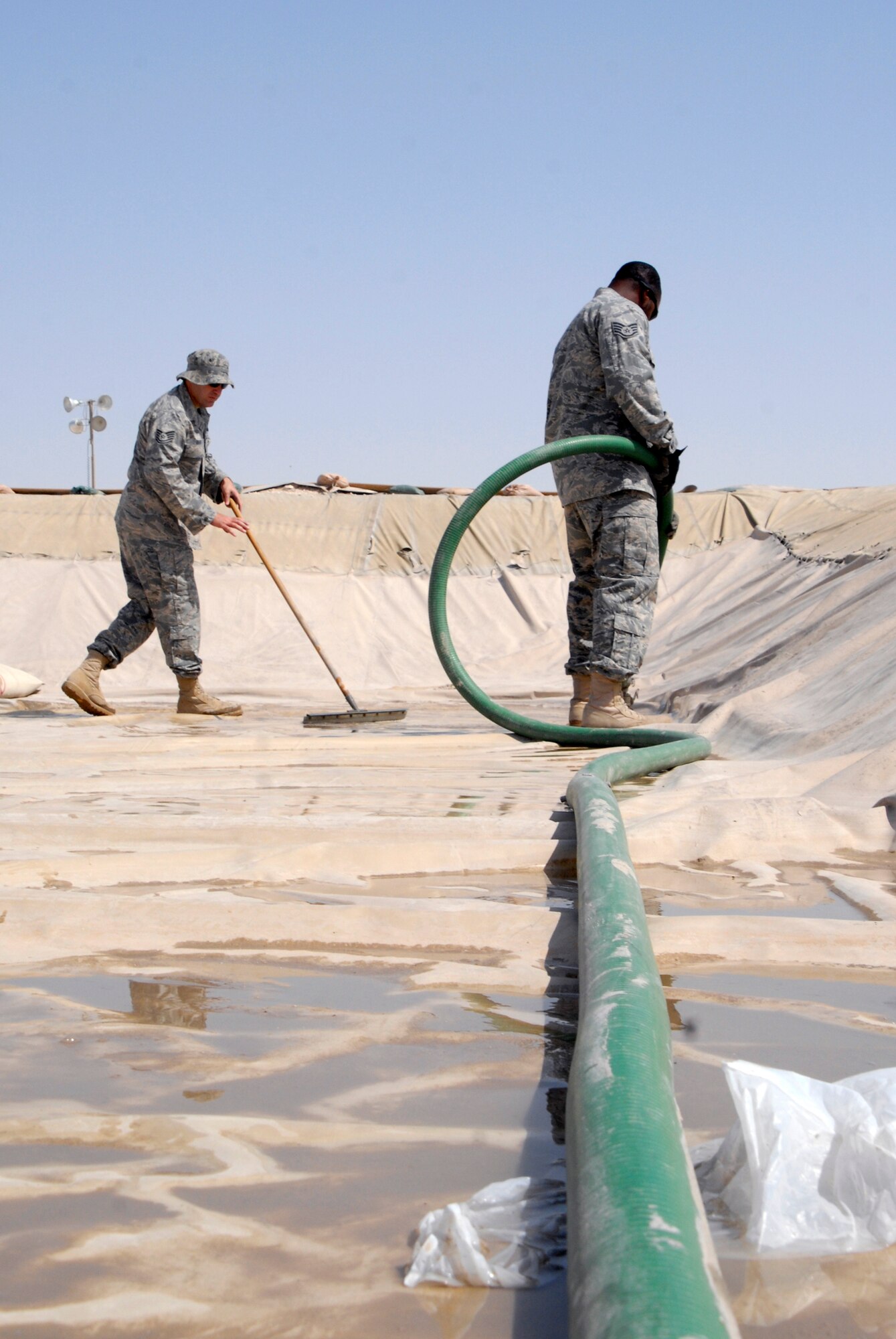 Tech. Sgt. John Neiffer (left) and Staff Sgt. Carmarius Johnson remove water in one of the fuel holding areas April 10 at an air base in Southwest Asia as a part of their preventative maintenance procedures.  Fuel stored here is distributed to various locations around the base where needed to ensure mission success. Sergeant Neiffer is the 379th Expeditionary Logistics Readiness Squadron NCO in charge of the bulk expeditionary receiving transportation holding area and hails from Pottstown, Pa. He is deployed from Offutt Air Force Base, Neb.  Sergeant Johnson, a bulk storage operator with the 379th ELRS, hails from Shreveport, La., and is deployed from Altus AFB, Okla.  (U.S. Air Force photo/Senior Airman Andrew Satran)