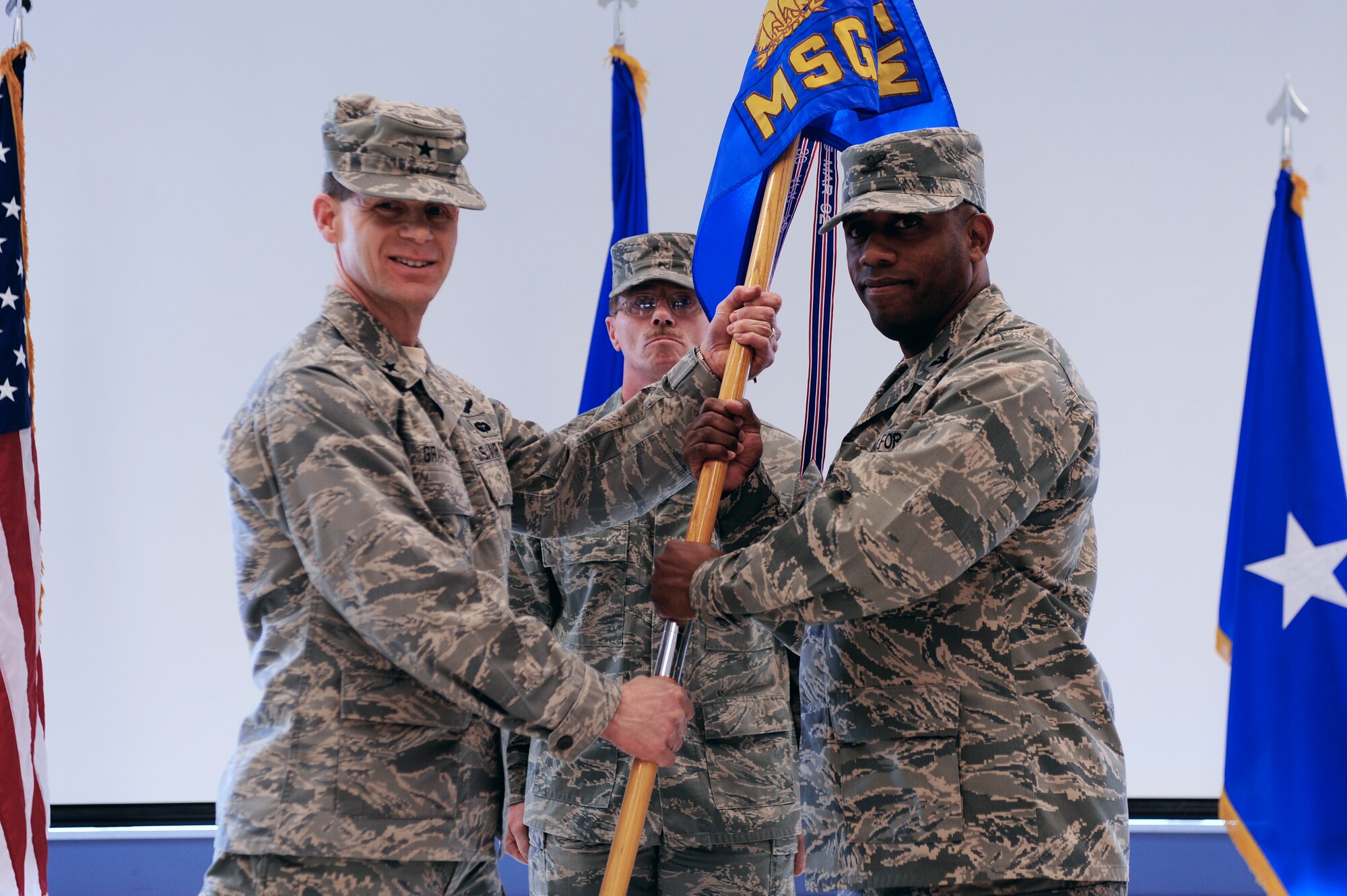 Brig. Gen. Mark Graper, 354th Fighter Wing commander, passes the guidon to Col. Karlton Johnson, 354th Mission Support Group commander, during the assumption of command ceremony April 7, 2009, Eielson Air Force Base, Alaska. The guidon symbolizes the relinquishment of authority from the outgoing commander to the incoming commander.  (U.S. Air Force photo/Senior Airman Jonathan Snyder)