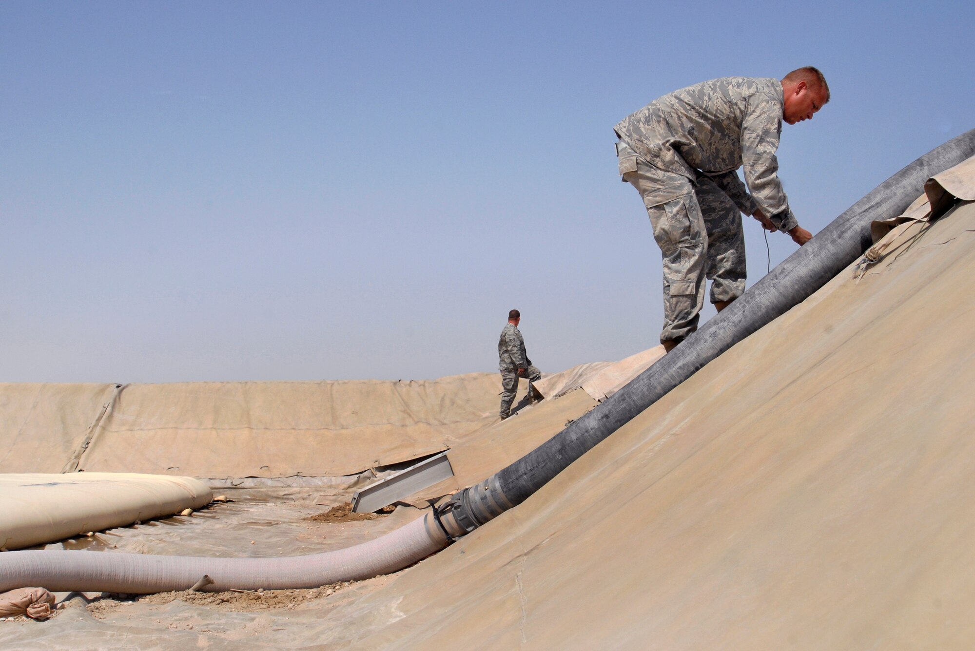 Tech. Sgt. Raymond Carpenter, 379th Expeditionary Logistics Readiness Squadron fuels bulk storage supervisor, ties and secures a berm liner down in the bulk expeditionary receiving transportation holding area (BERTHA), Apr. 10, 2009, at an undisclosed location in Southwest Asia.  The fuel held in the BERTHA is distributed to various locations around the base where needed to ensure mission success.  Sergeant Carpenter hails from Princeton, Idaho and is deployed from Ellsworth Air Force Base, S.D. in support of Operations Iraqi and Enduring Freedom and Combined Joint Task Force - Horn of Africa.  (U.S. Air Force photo/Senior Airman Andrew Satran/released)  
