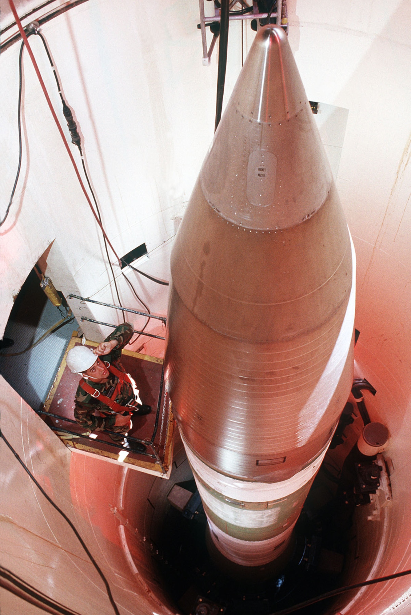 A maintainer looks over a Minuteman III in a silo about 60 miles from Grand Forks AFB, N.D., in 1989. (U.S. Air Force photo)